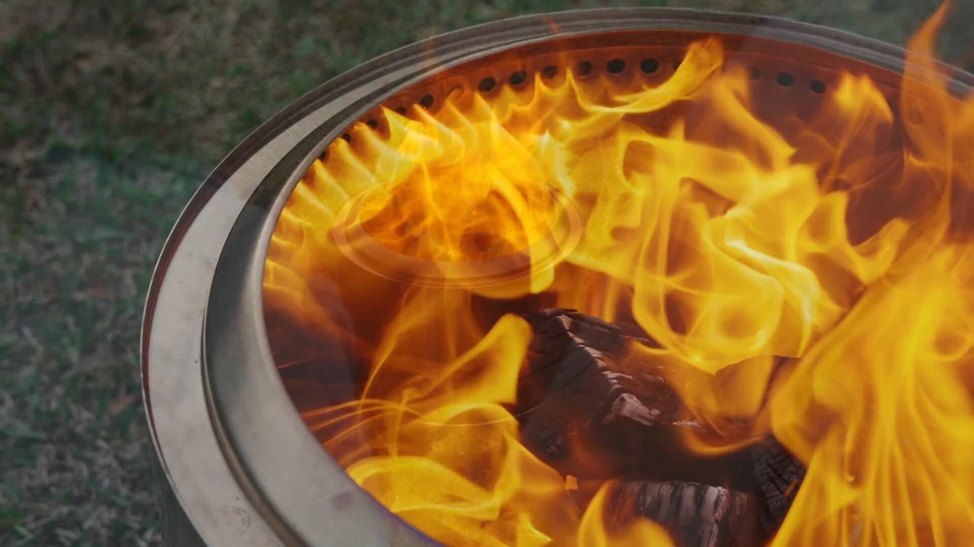 Variety of fire pit accessories displayed on grass lawn